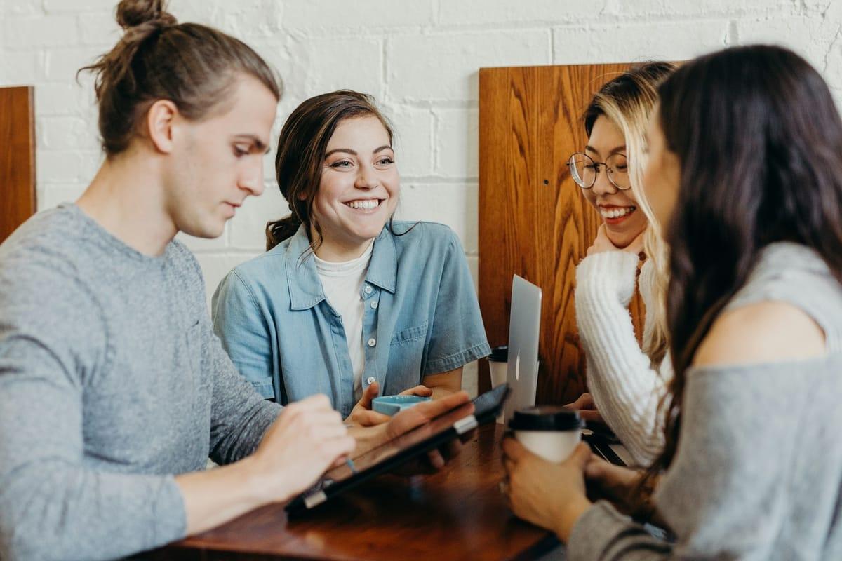 Four friends at a cafe with every face auto-blurred — original