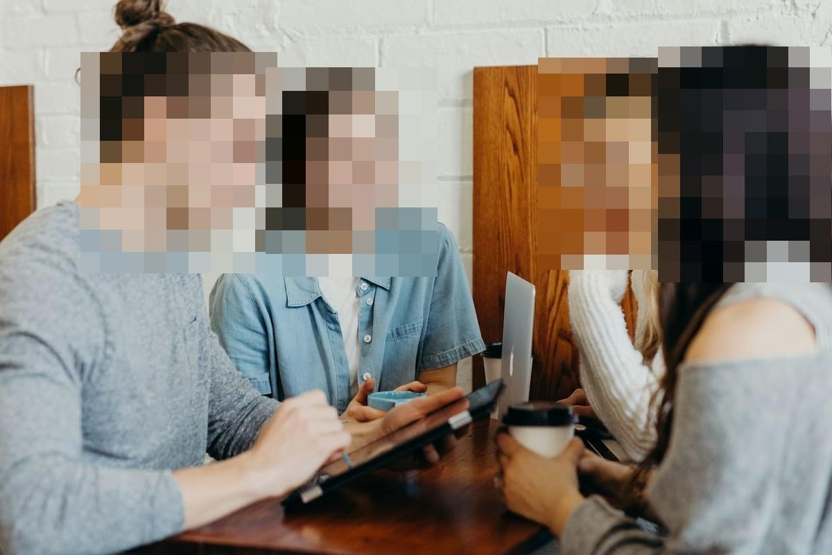 Group photo with every face censored by hard pixel blocks — Blurify result